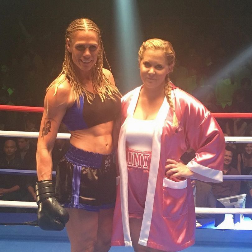 Two women in boxing gear pose for a picture.